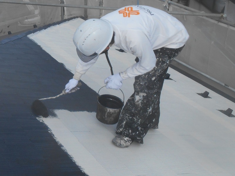 屋根に遮熱塗料を塗装中